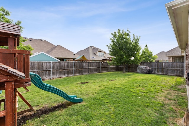 view of yard featuring a playground and a fenced backyard