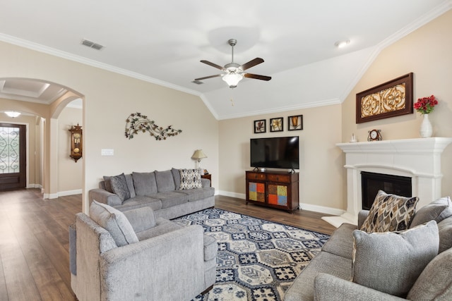 living room featuring a ceiling fan, visible vents, arched walkways, wood finished floors, and baseboards