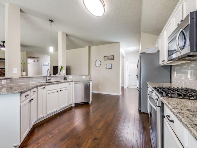 8410 Victory St, Rowlett, TX 75089 - kitchen with white cabinets, a sink, stainless steel appliances, tasteful backsplash, and dark wood-style floors