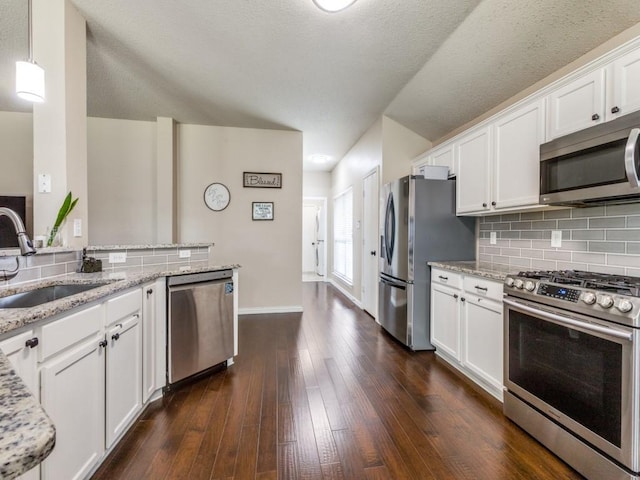 8410 Victory St, Rowlett, TX 75089 - kitchen with decorative backsplash, appliances with stainless steel finishes, a sink, light stone counters, and white cabinetry