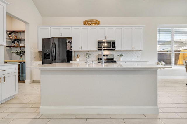 kitchen with light countertops, appliances with stainless steel finishes, light tile patterned floors, and tasteful backsplash