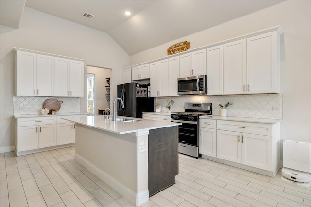 kitchen with visible vents, appliances with stainless steel finishes, tasteful backsplash, a sink, and light countertops