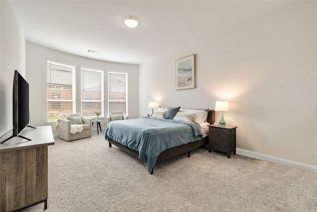 bedroom with visible vents, baseboards, and light carpet