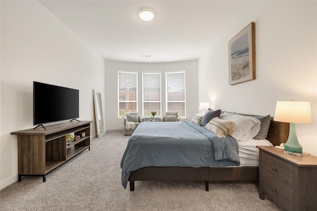 bedroom with baseboards, visible vents, and light carpet