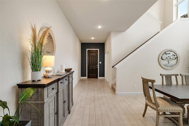 entrance foyer with baseboards, light wood-type flooring, recessed lighting, and stairs
