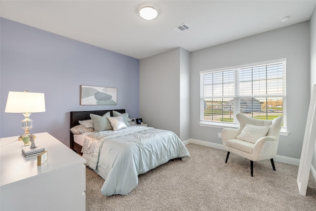 bedroom with baseboards, light carpet, and visible vents