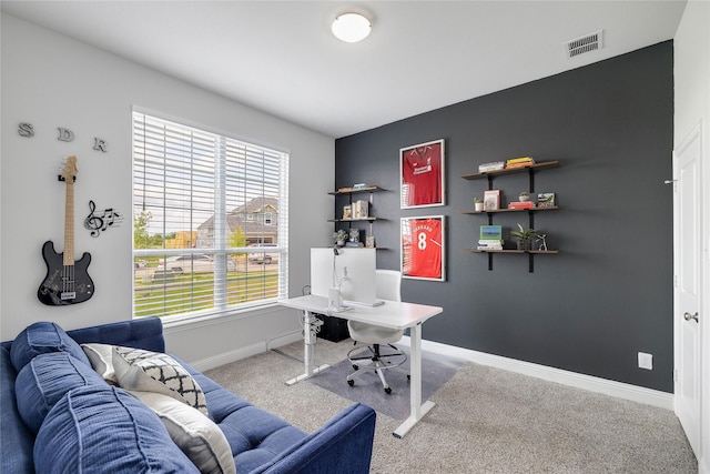 office featuring carpet flooring, baseboards, visible vents, and a wealth of natural light