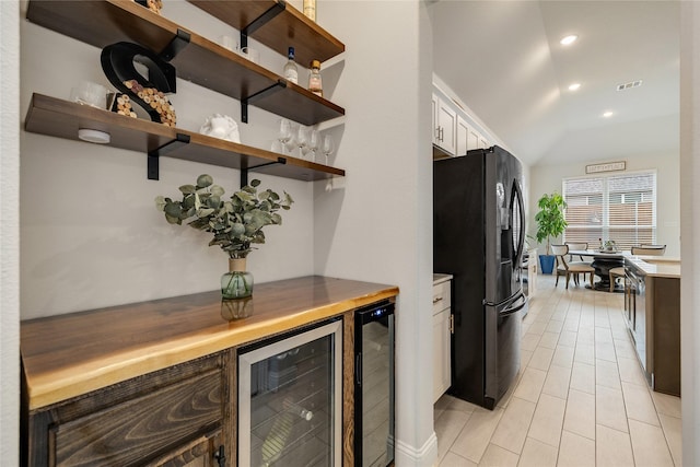704 Fencerow Trl, Weston, TX 75009 - kitchen with black fridge with ice dispenser, beverage cooler, white cabinets, lofted ceiling, and light countertops