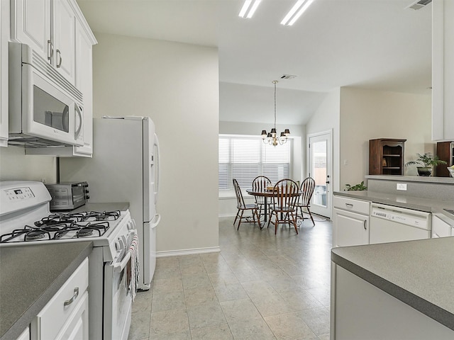 kitchen with white appliances, white cabinetry, baseboards, and a chandelier
