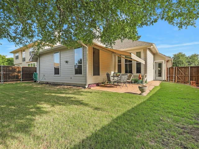 rear view of property featuring a yard and a fenced backyard