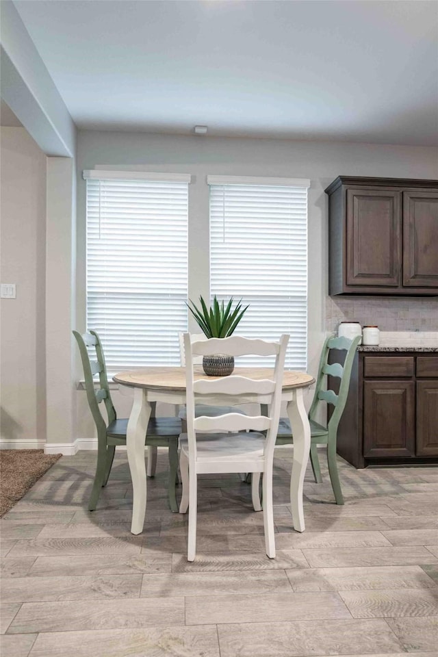 dining space featuring baseboards and plenty of natural light
