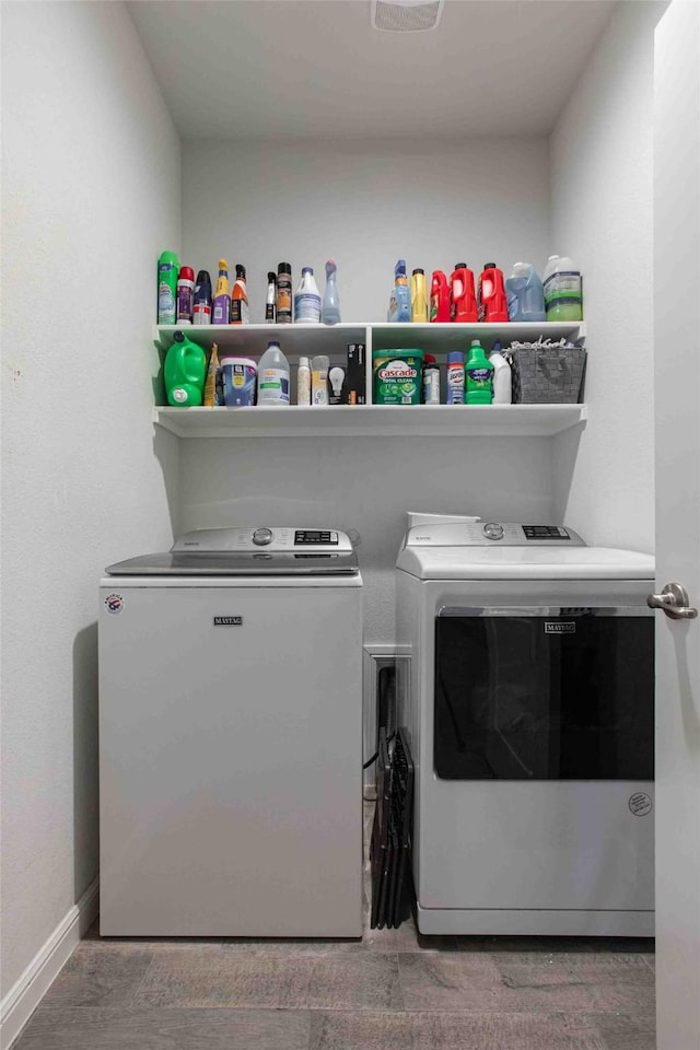 clothes washing area with baseboards, laundry area, and washer and clothes dryer