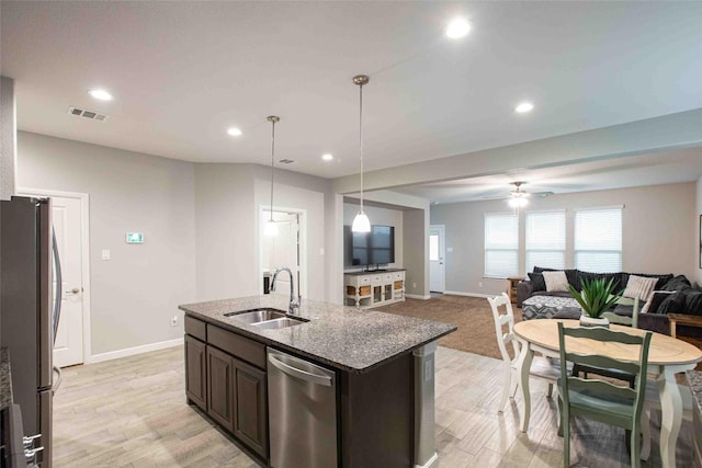 kitchen with visible vents, appliances with stainless steel finishes, dark brown cabinets, a sink, and baseboards
