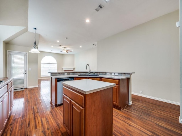kitchen featuring a sink, brown cabinetry, a center island, stainless steel dishwasher, and visible vents