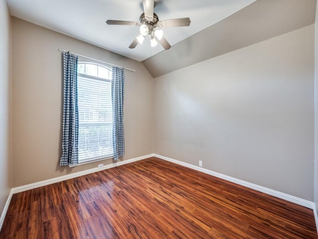 spare room featuring a ceiling fan, baseboards, lofted ceiling, and dark wood-type flooring