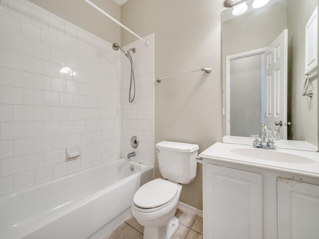 bathroom with vanity, toilet, baseboards, tile patterned floors, and  shower combination