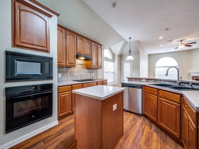 kitchen with dark wood-style flooring, a center island, tasteful backsplash, a sink, and black appliances