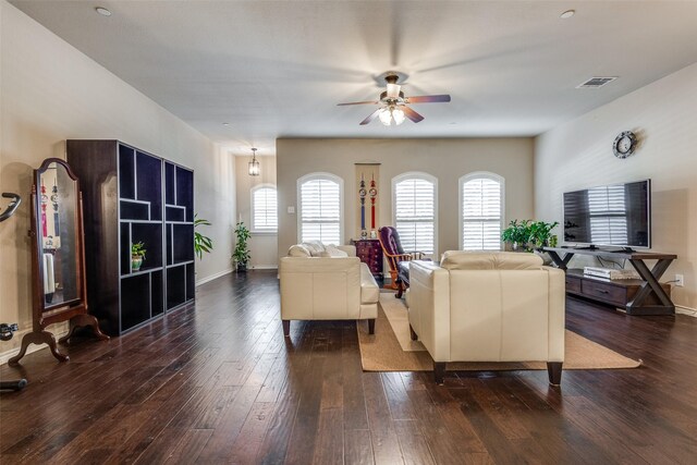 living area with visible vents, a ceiling fan, baseboards, and dark wood-style floors