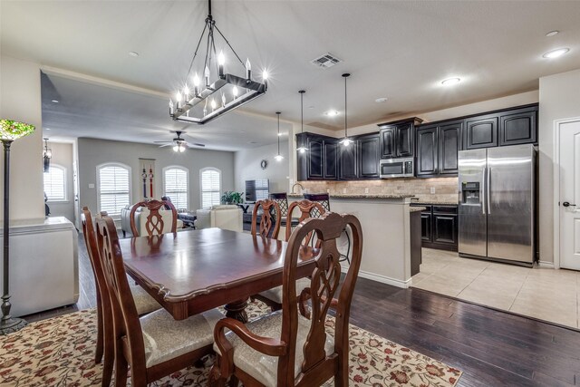 dining room featuring visible vents, recessed lighting, light wood finished floors, and ceiling fan with notable chandelier