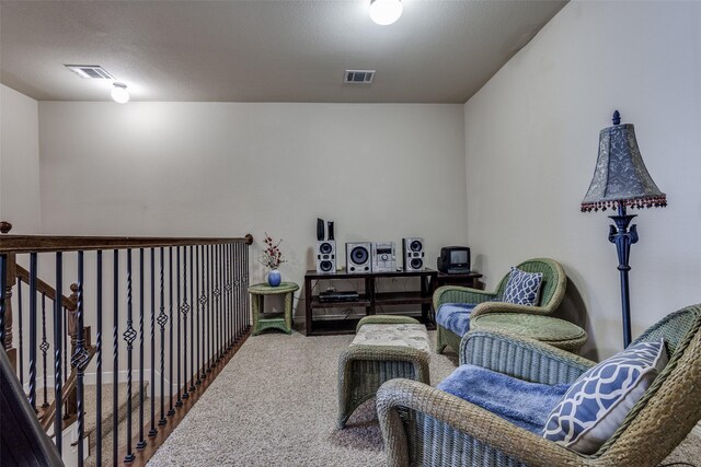 living area featuring carpet flooring and visible vents