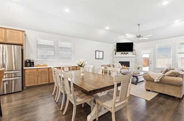 dining area featuring lofted ceiling, dark wood-style floors, a lit fireplace, recessed lighting, and a ceiling fan