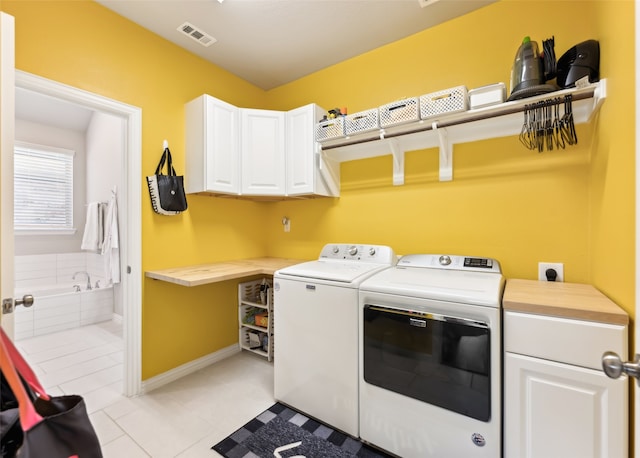 laundry room featuring visible vents, light tile patterned flooring, washer and dryer, baseboards, and cabinet space