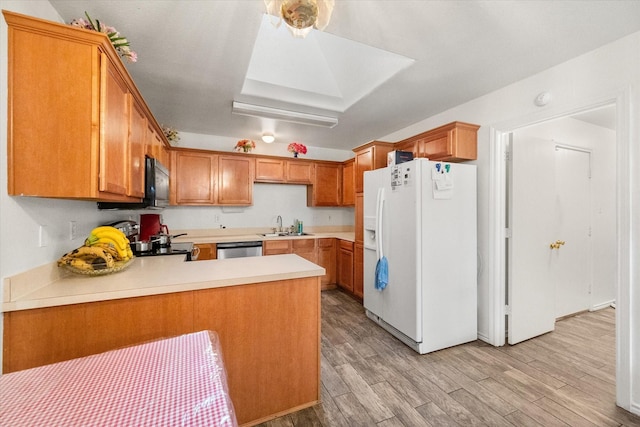 kitchen featuring stainless steel dishwasher, a peninsula, white refrigerator with ice dispenser, light countertops, and light wood finished floors