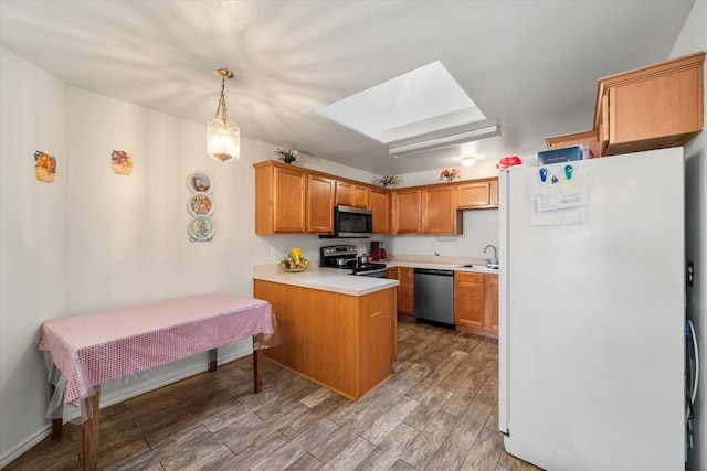 kitchen with appliances with stainless steel finishes, a sink, light wood-style flooring, a peninsula, and a skylight