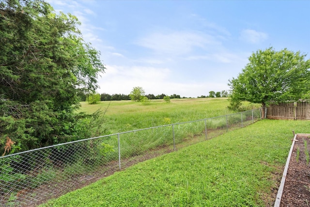 view of yard featuring fence and a rural view