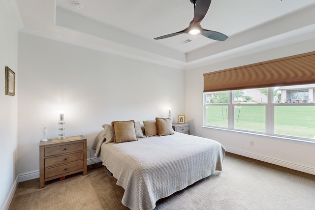 bedroom with a raised ceiling, baseboards, light colored carpet, and visible vents