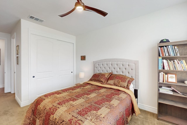 carpeted bedroom with a ceiling fan, baseboards, visible vents, and a closet