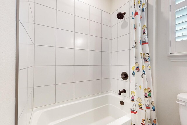 full bathroom featuring toilet and shower / tub combo with curtain