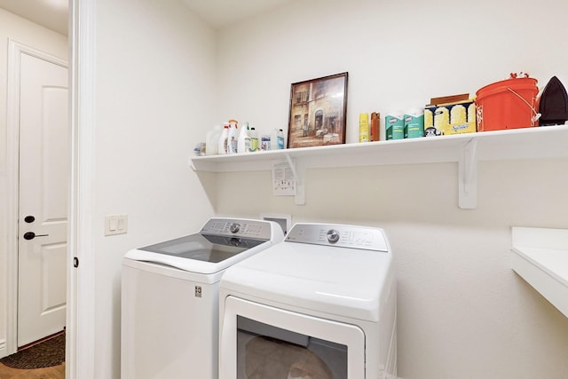clothes washing area featuring separate washer and dryer, laundry area, and wood finished floors