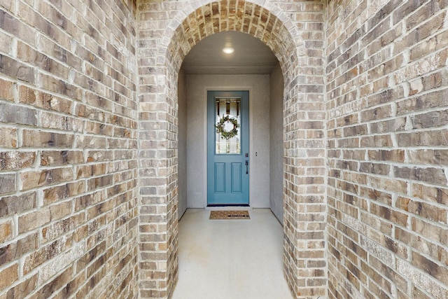 doorway to property featuring brick siding