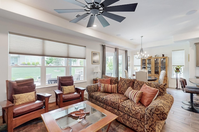 living room featuring wood finished floors and ceiling fan with notable chandelier