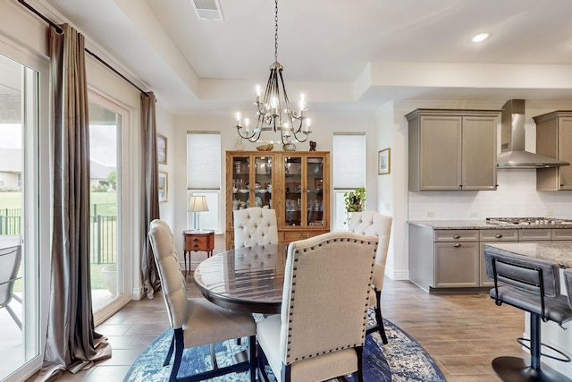 dining room with visible vents, light wood finished floors, a chandelier, and a wealth of natural light