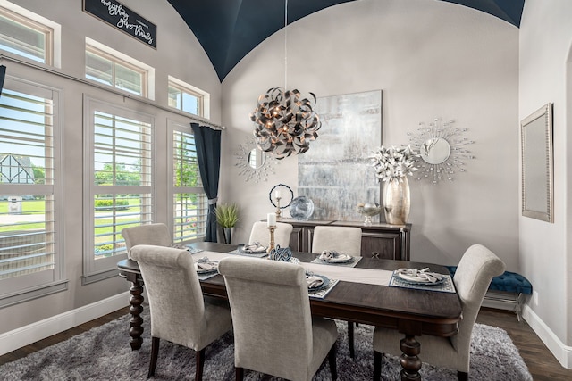 dining room featuring baseboards, vaulted ceiling, and wood finished floors
