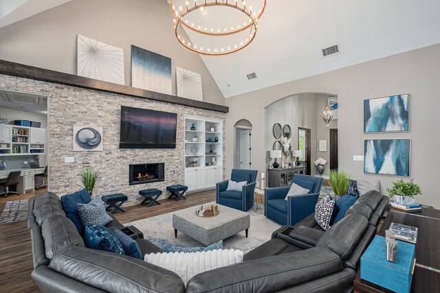 living room with arched walkways, high vaulted ceiling, built in features, wood finished floors, and visible vents