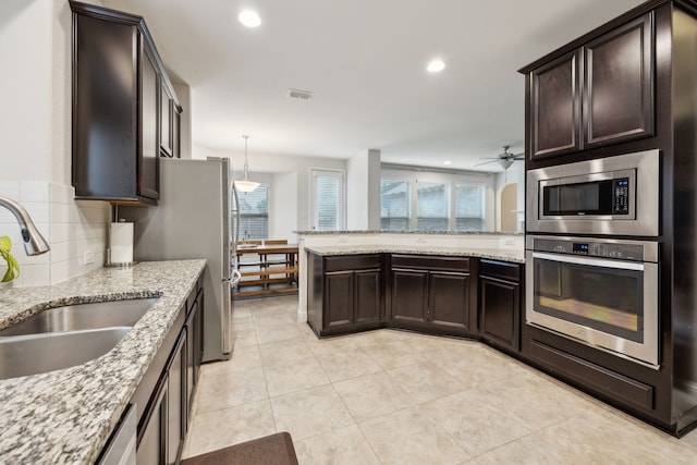 kitchen with ceiling fan, dark brown cabinetry, visible vents, a sink, and stainless steel appliances