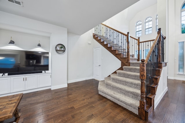 stairs featuring visible vents, baseboards, and hardwood / wood-style floors