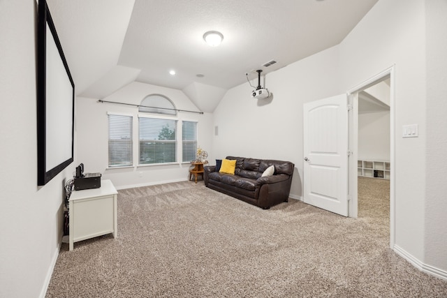 carpeted living room featuring baseboards and vaulted ceiling