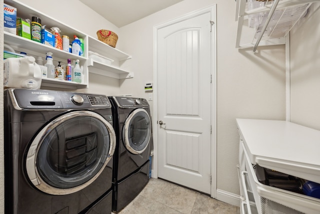 clothes washing area with laundry area, baseboards, independent washer and dryer, and light tile patterned floors