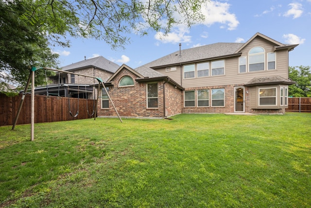 back of house with a lawn, brick siding, a shingled roof, and a fenced backyard