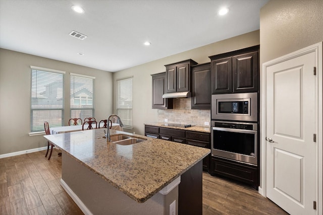 7809 Bella Way, Arlington, TX 76001 - kitchen with stainless steel appliances, a sink, an island with sink, backsplash, and dark wood-style flooring