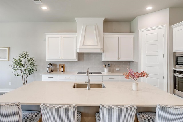 kitchen featuring a breakfast bar area, stainless steel appliances, a sink, and tasteful backsplash