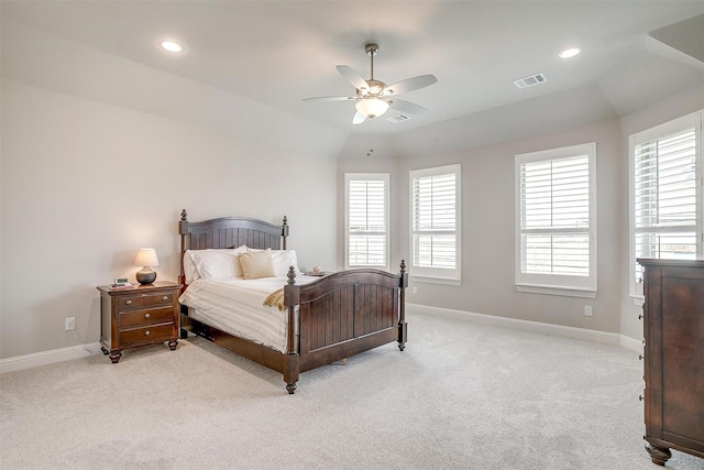 bedroom with baseboards, visible vents, light carpet, and multiple windows