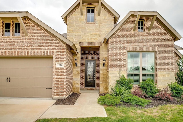 view of front of property featuring brick siding, driveway, and stone siding