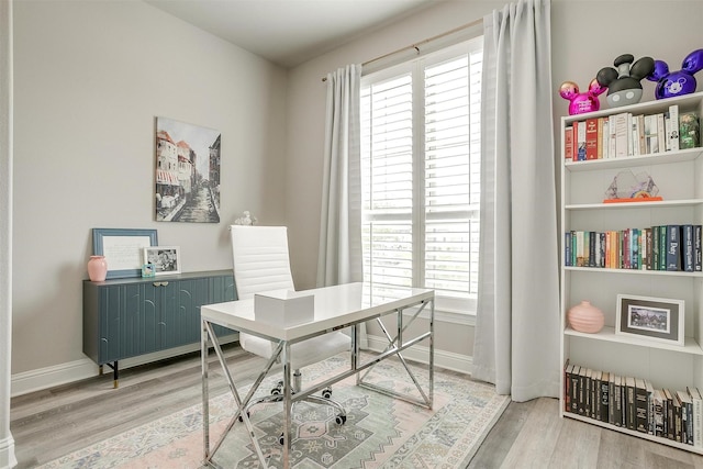 office space with baseboards and light wood-style flooring
