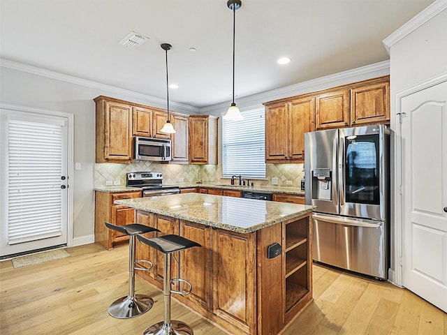 2500 Rockbrook Dr Unit 81, Lewisville, TX 75067 - kitchen featuring visible vents, light wood-style floors, brown cabinets, and stainless steel appliances