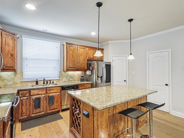 2500 Rockbrook Dr Unit 81, Lewisville, TX 75067 - kitchen featuring a sink, appliances with stainless steel finishes, brown cabinets, and light wood-style flooring